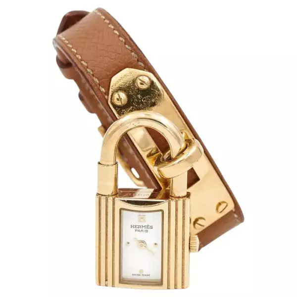 Часы с подписью Дома Hermès из позолоченной кожи и коричневой кожи. Модель Келли. Часы с подписью Дома Hermès из позолоченной кожи и коричневой кожи. Модель Келли.