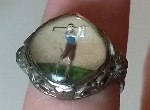 Серебряное кольцо с миниатюрной картиной изображающей игру в гольф.